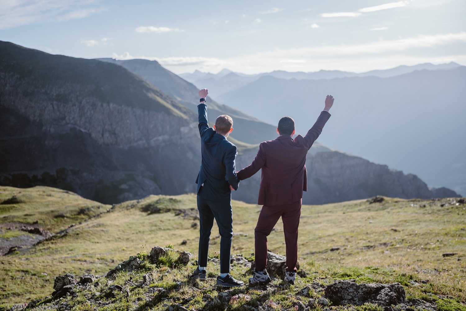 Two groom celebrating their elopement on a mountain in Colorado.